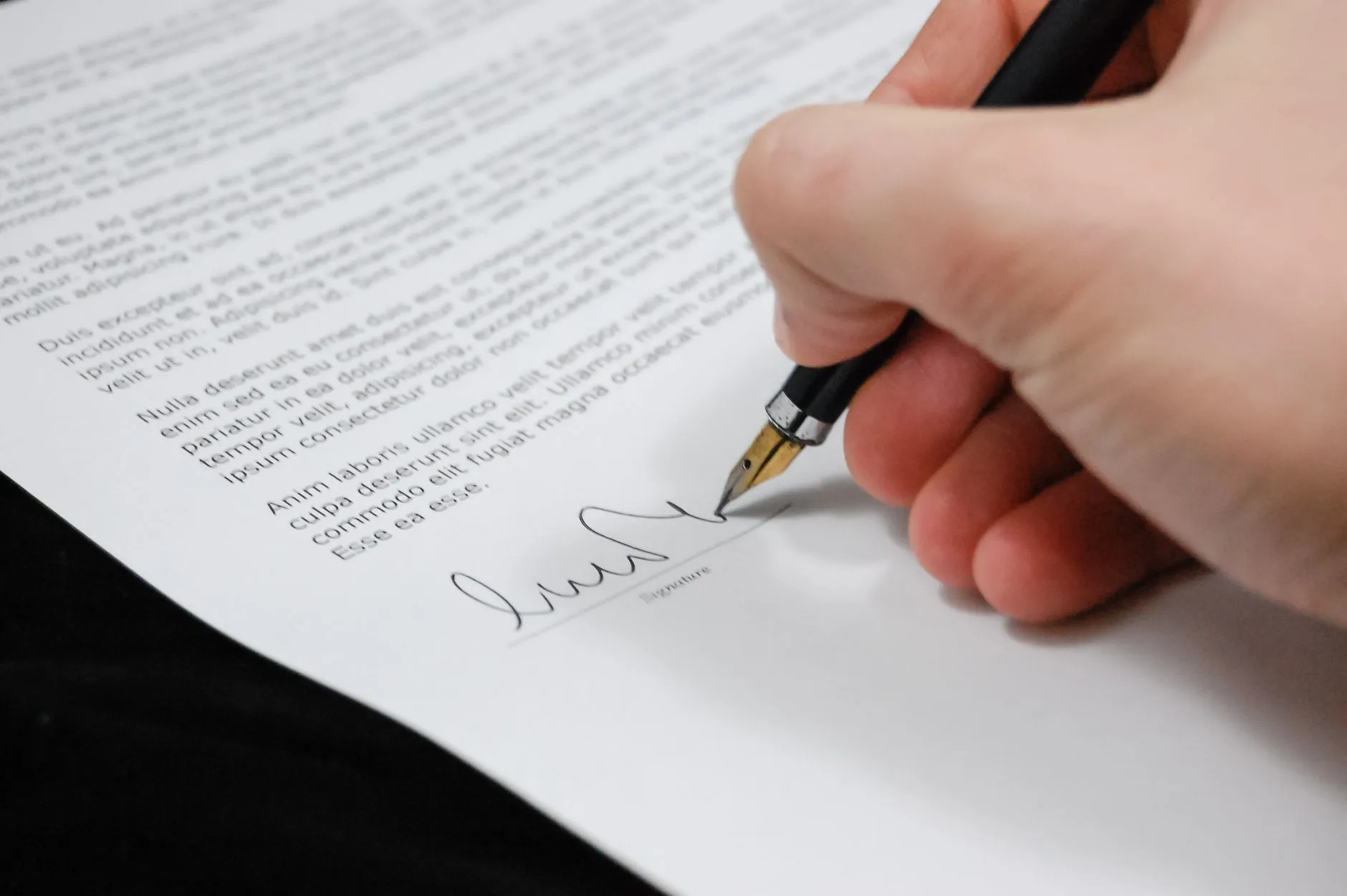 Mano firmando un documento clínico, como pide la NOM-004 para cada apartado del expediente.