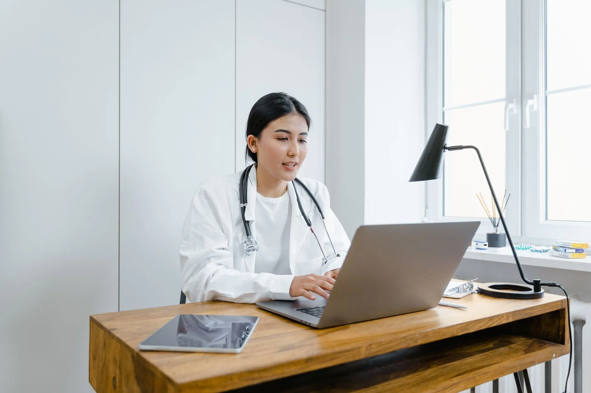 Profesional de la salud usando una laptop para gestionar el expediente clínico electrónico.