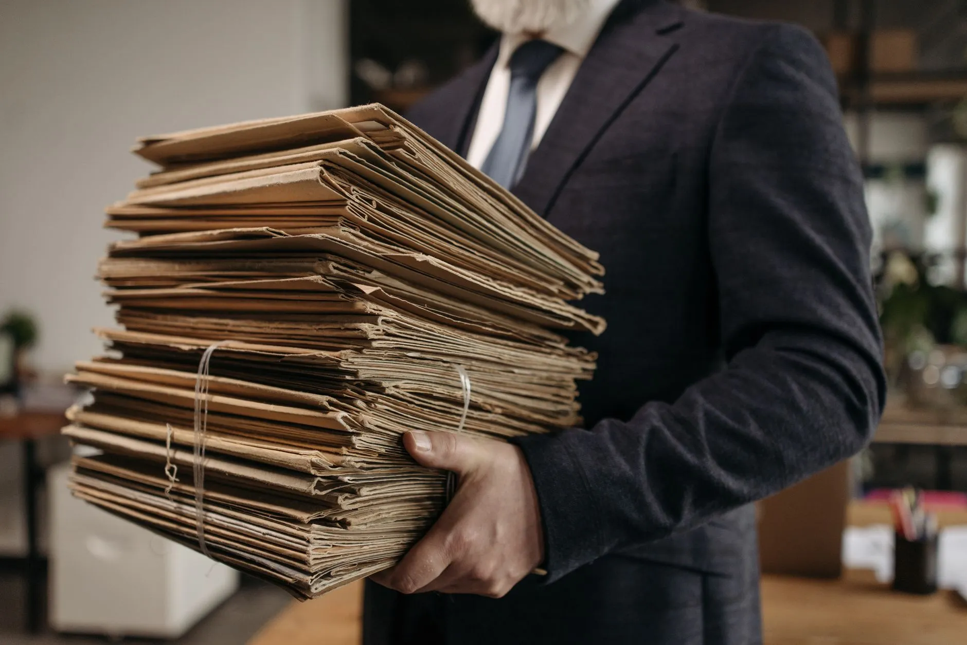 Carpetas y documentos apilados que representan el expediente clínico, la historia clínica y las notas de evolución.
