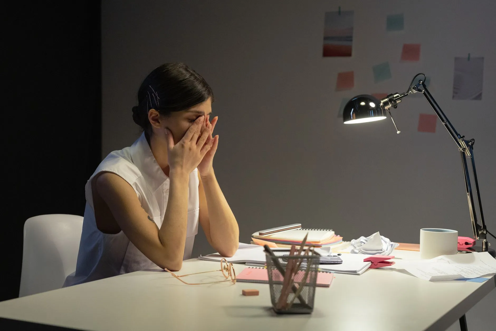 Profesional cansada frente a su escritorio al final del día, reflejo de los errores comunes al dar acompañamiento psicológico.