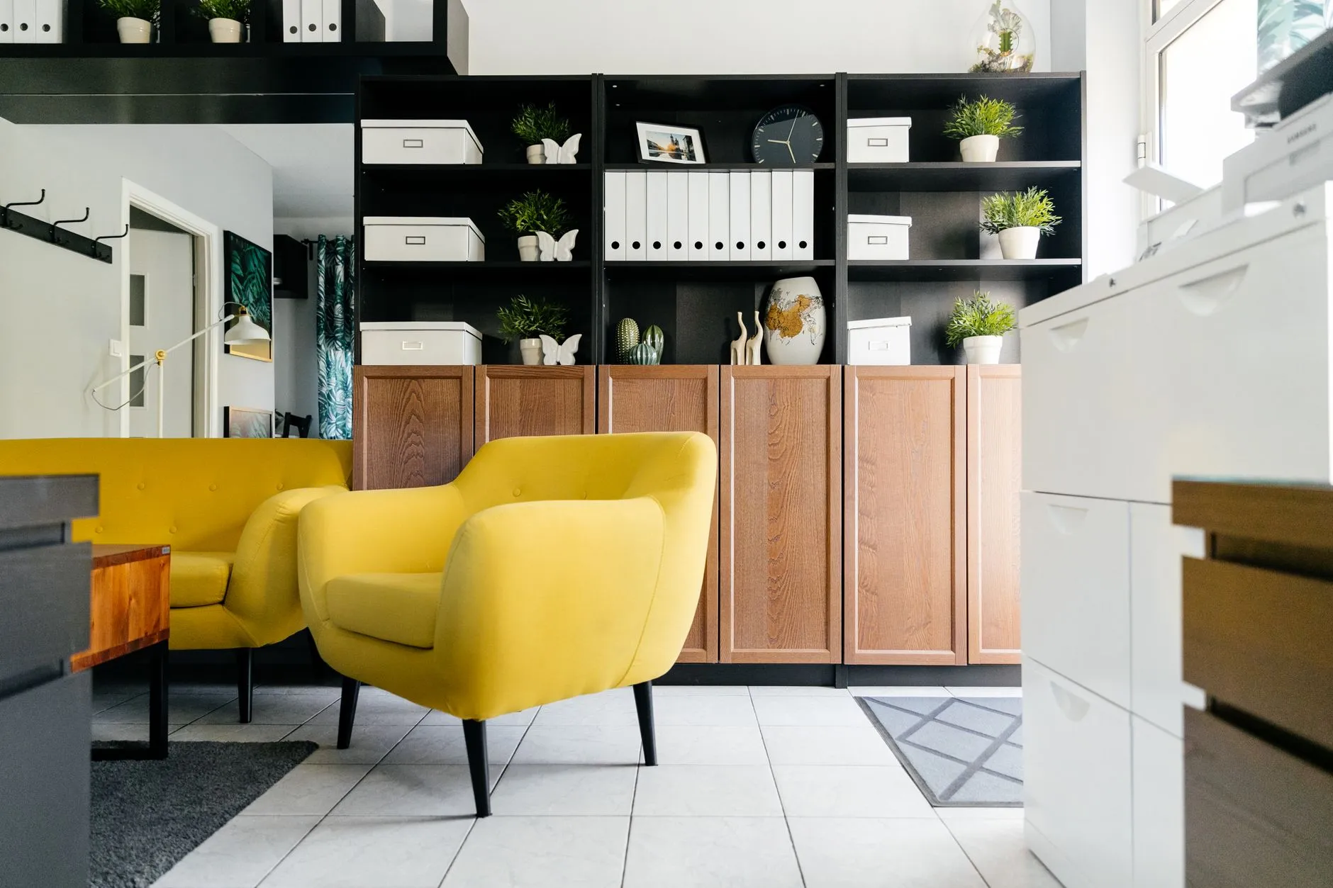 Espacio acogedor de un consultorio de psicología en casa, con sillones y plantas.
