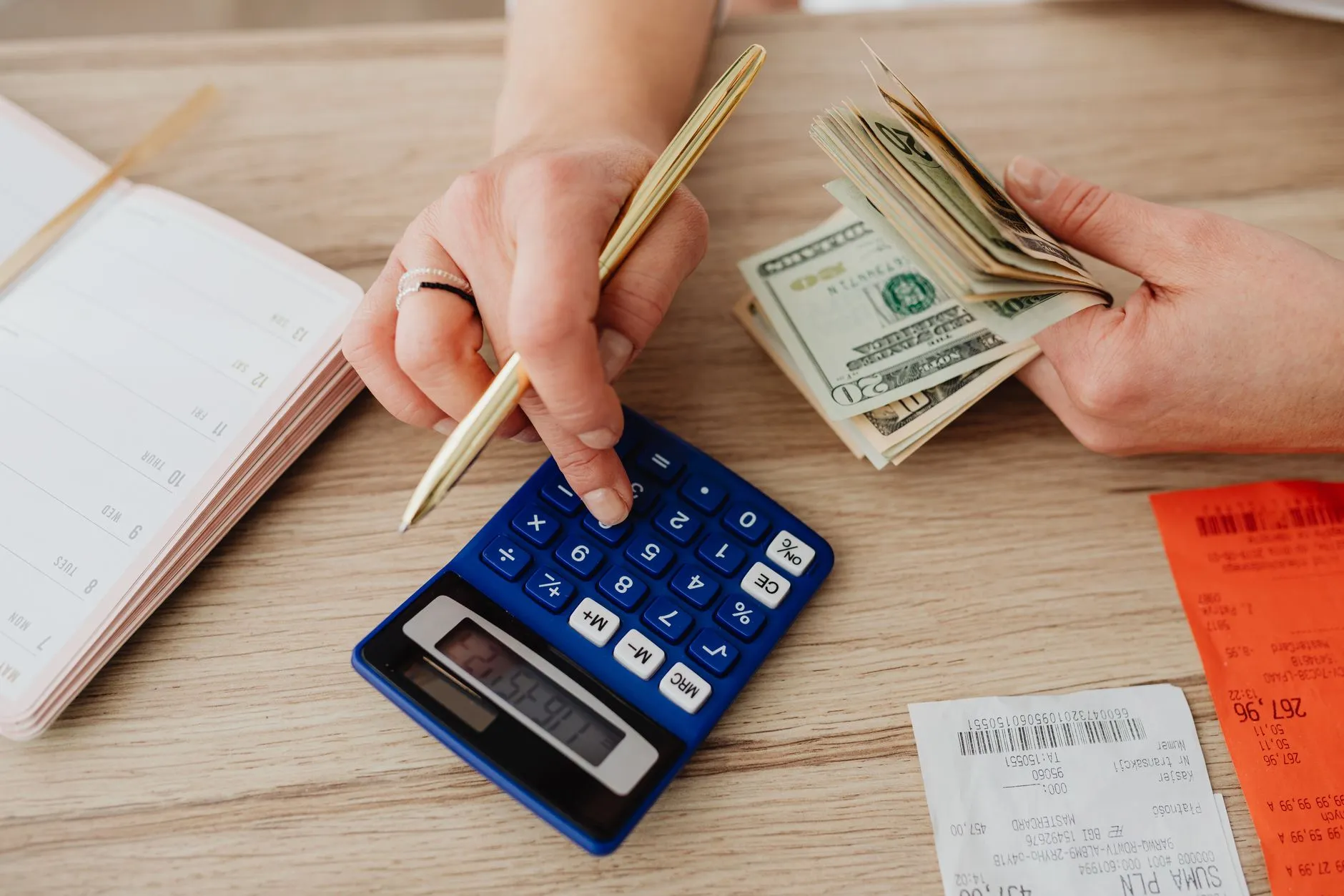 Psicólogo planeando el enfoque y las tarifas de su consulta con cuaderno y calculadora.