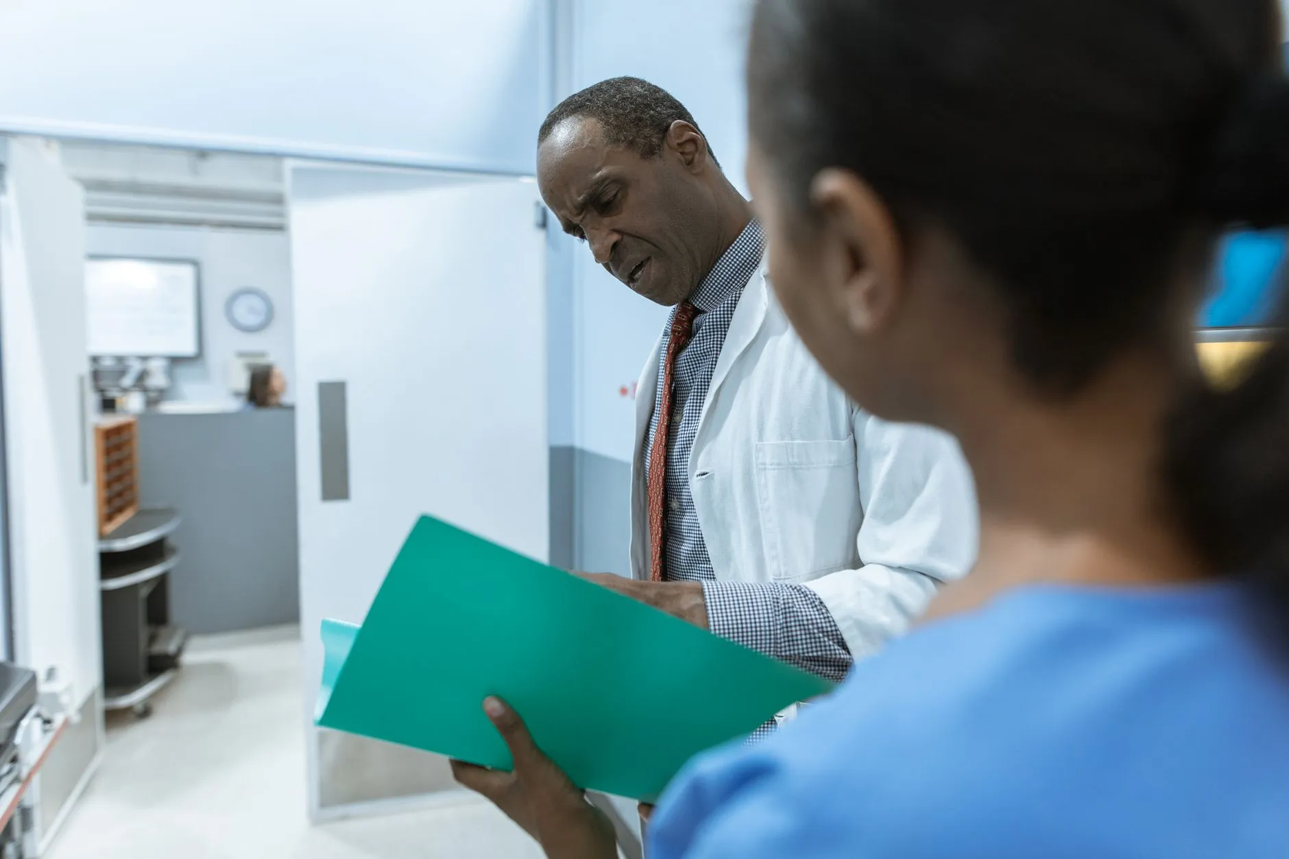 Psicólogo revisando el expediente clínico de un paciente en el pasillo del consultorio.