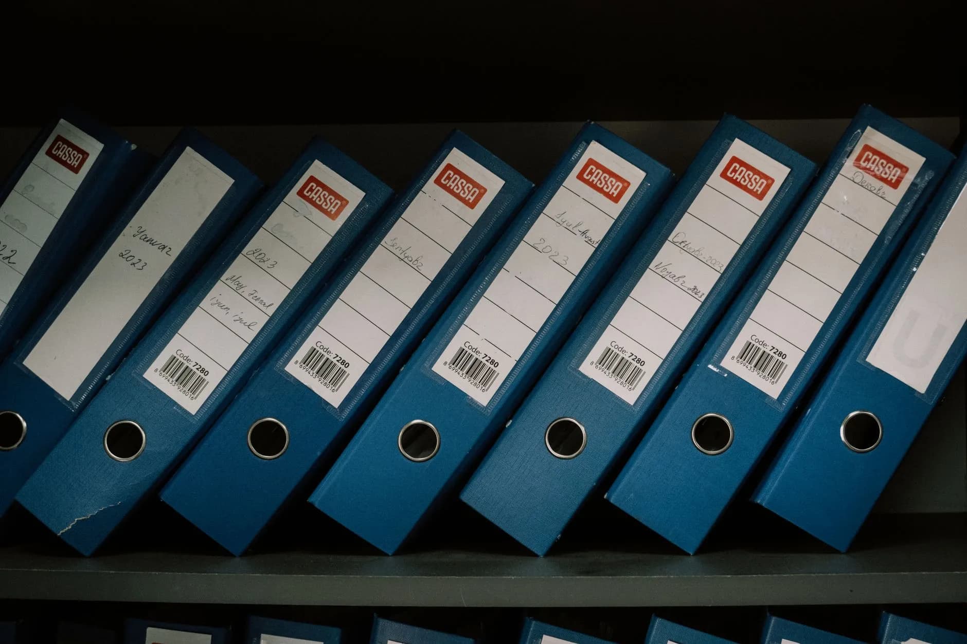 Carpetas de expedientes clínicos psicológicos organizadas y etiquetadas en un archivo ordenado.