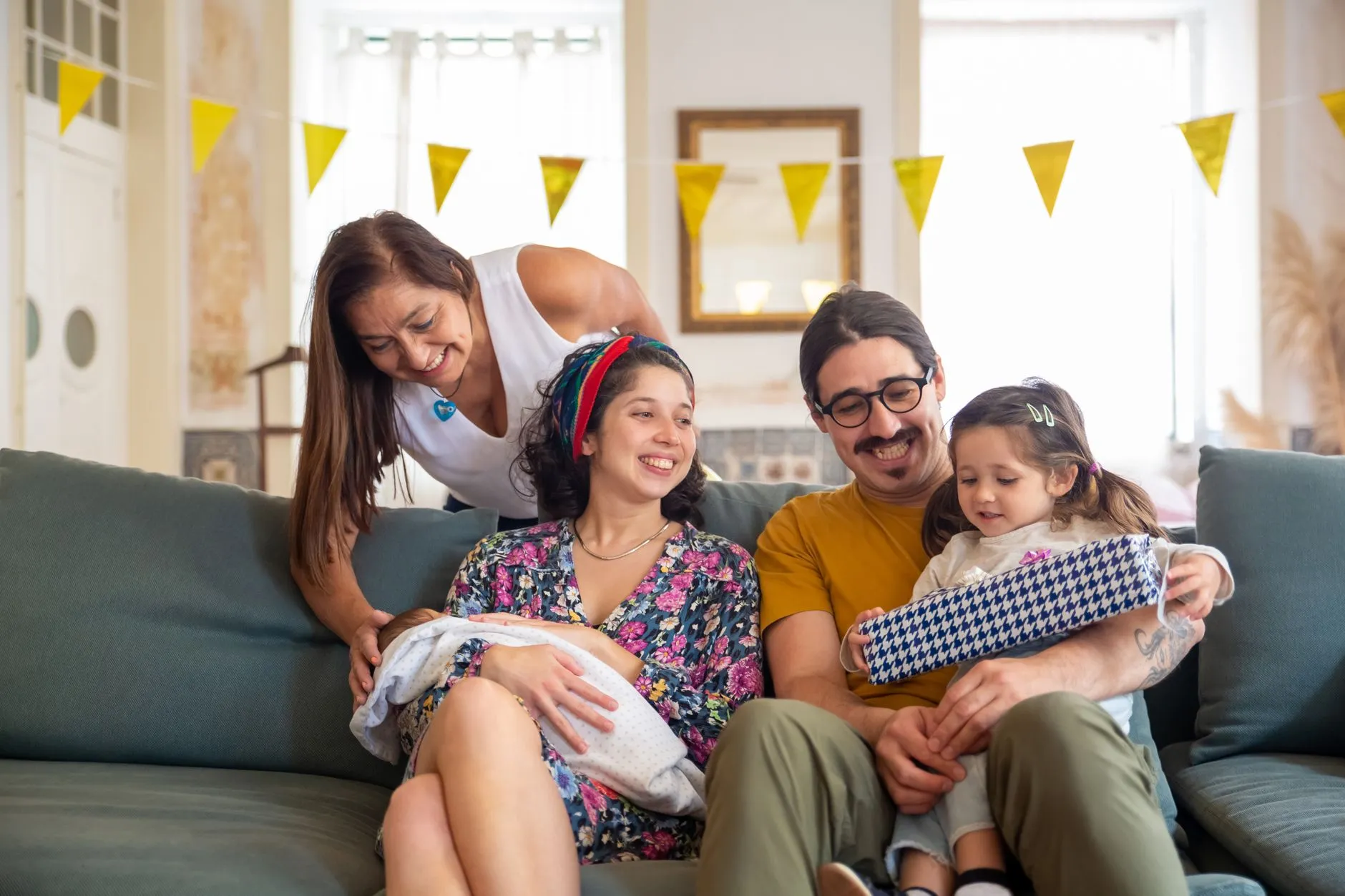 Familia sentada en un sillón platicando, ejemplo del sistema familiar que observa el modelo sistémico en psicología.