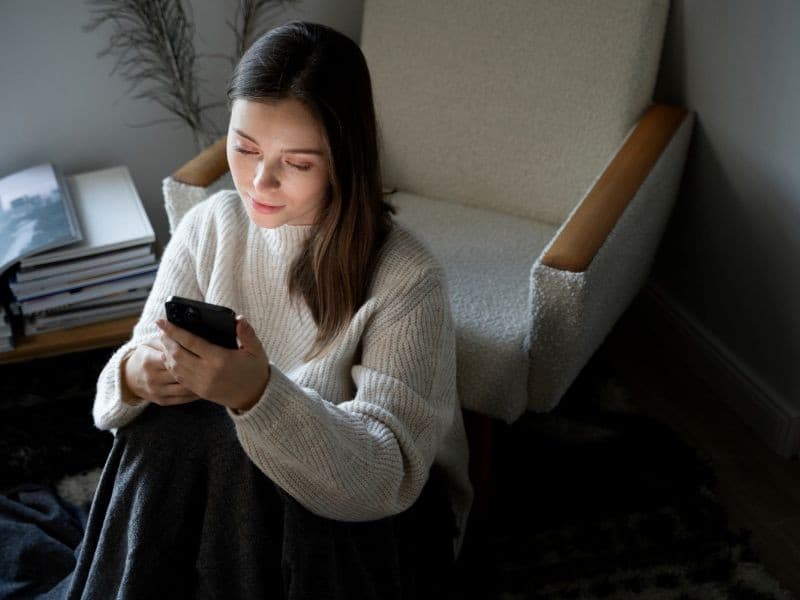 Mujer usando celular preocupada por ghosting