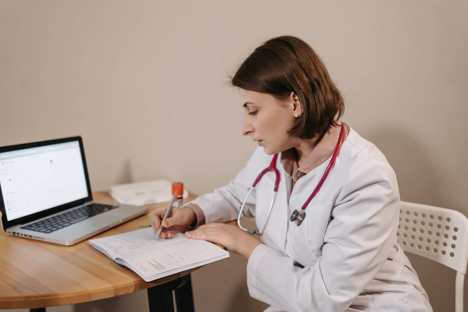 Profesional registrando información de un paciente en una laptop, tarea común a todas las ramas de la psicología aplicada.