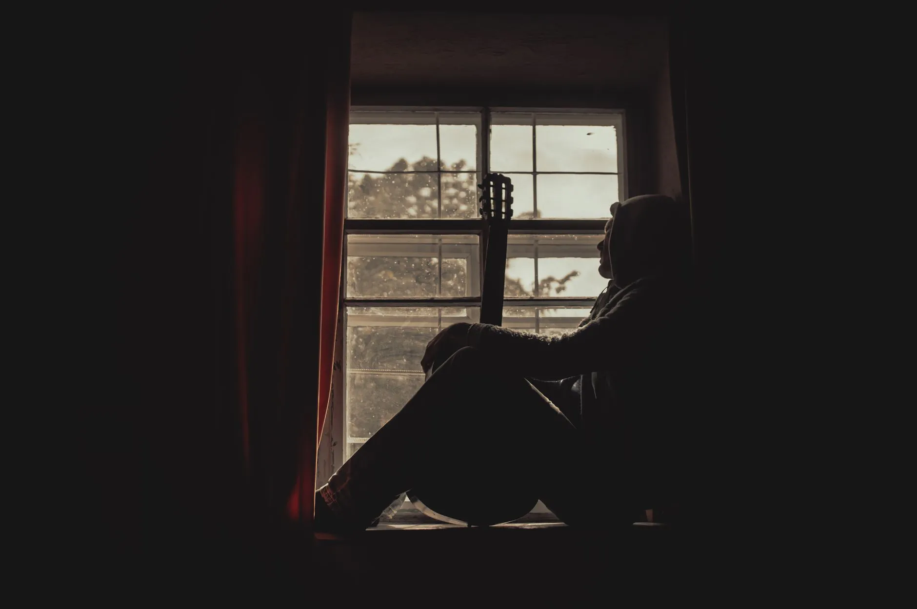 Persona pensativa junto a una ventana, imagen asociada a los trastornos psicológicos.